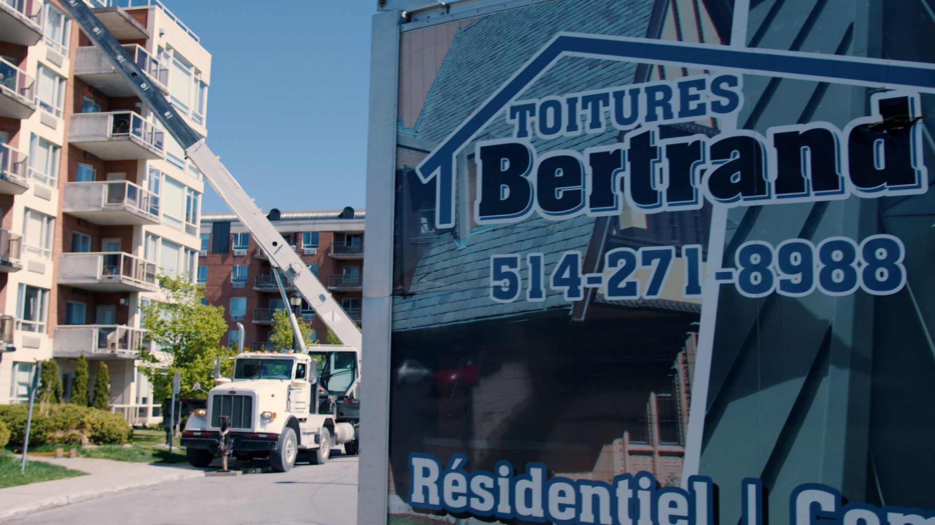 A truck is parked in front of a sign that says toitures bertand