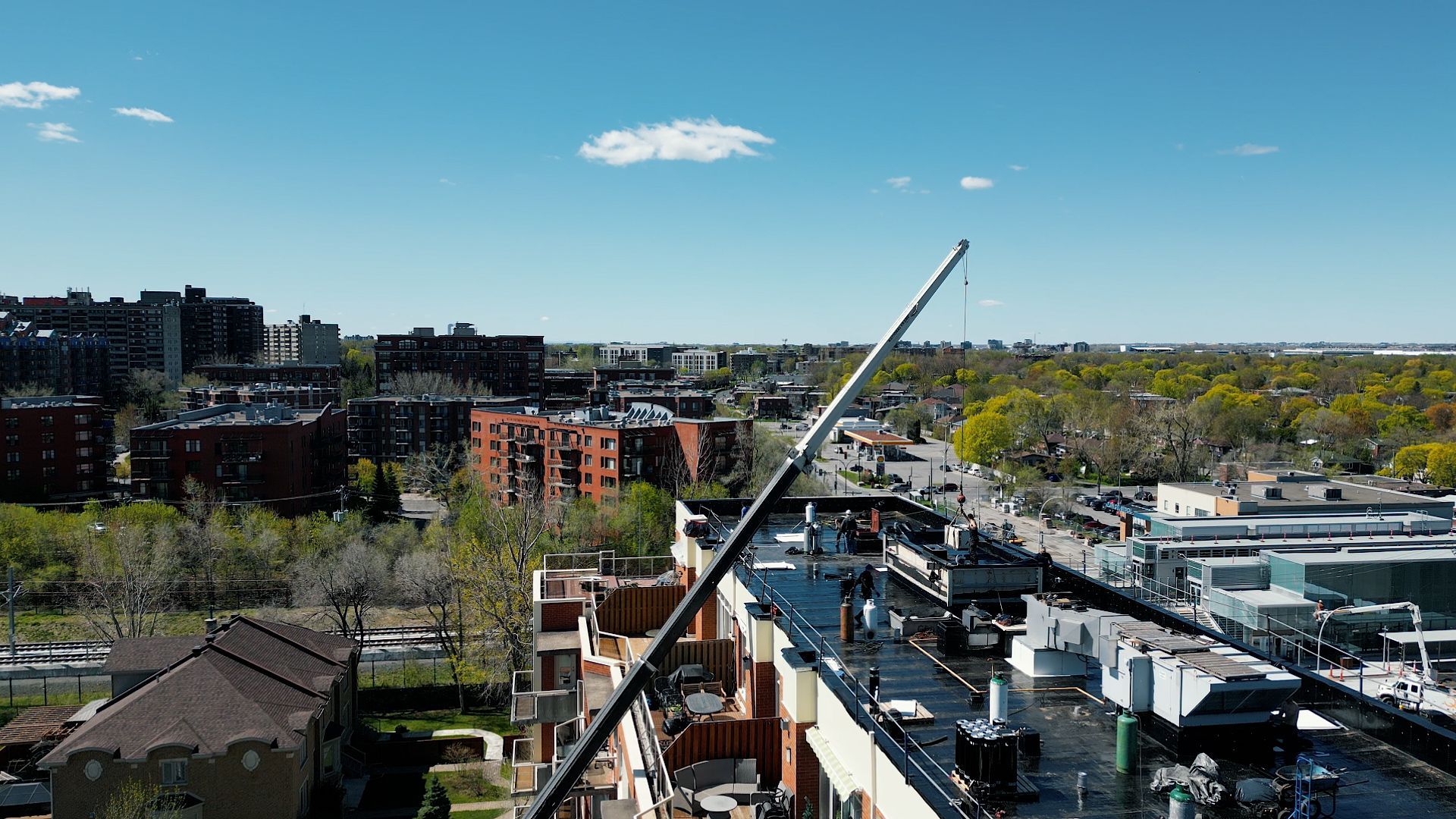 An aerial view of a city with a crane on top of a building.