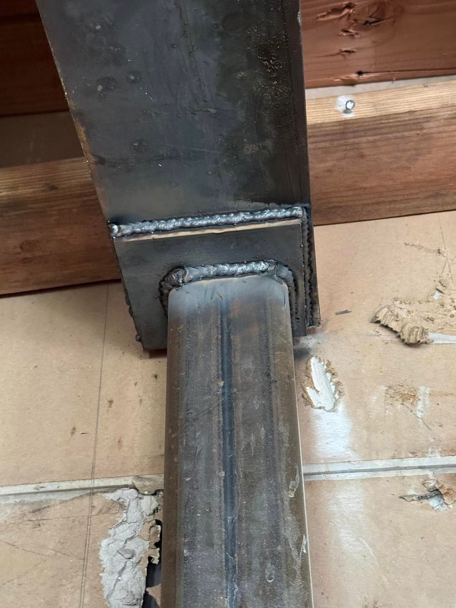 Welded steel beam supporting ceiling joist; a sturdy structure.