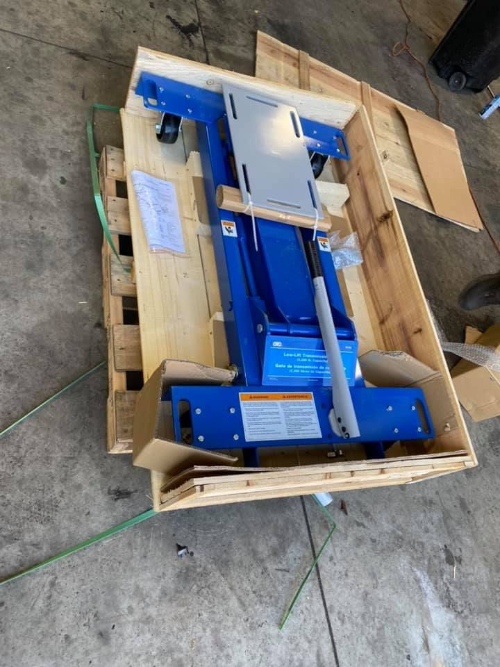 Blue car lift in wooden crate on a pallet.