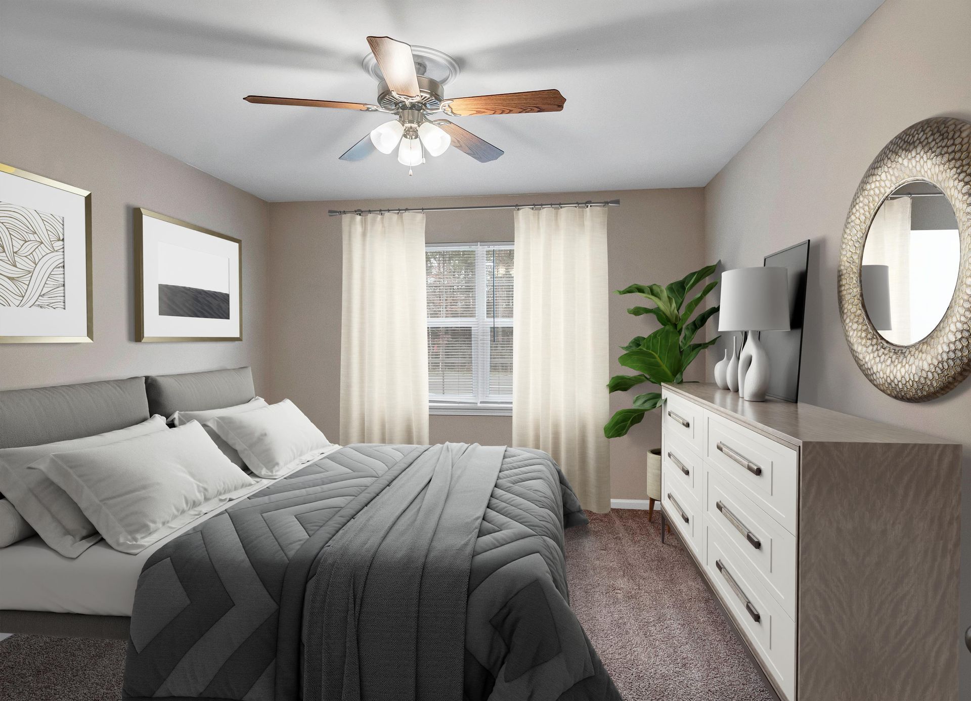 A modern bedroom featuring a bed with gray bedding, a white dresser, a circular mirror, a window with curtains, and a fan.