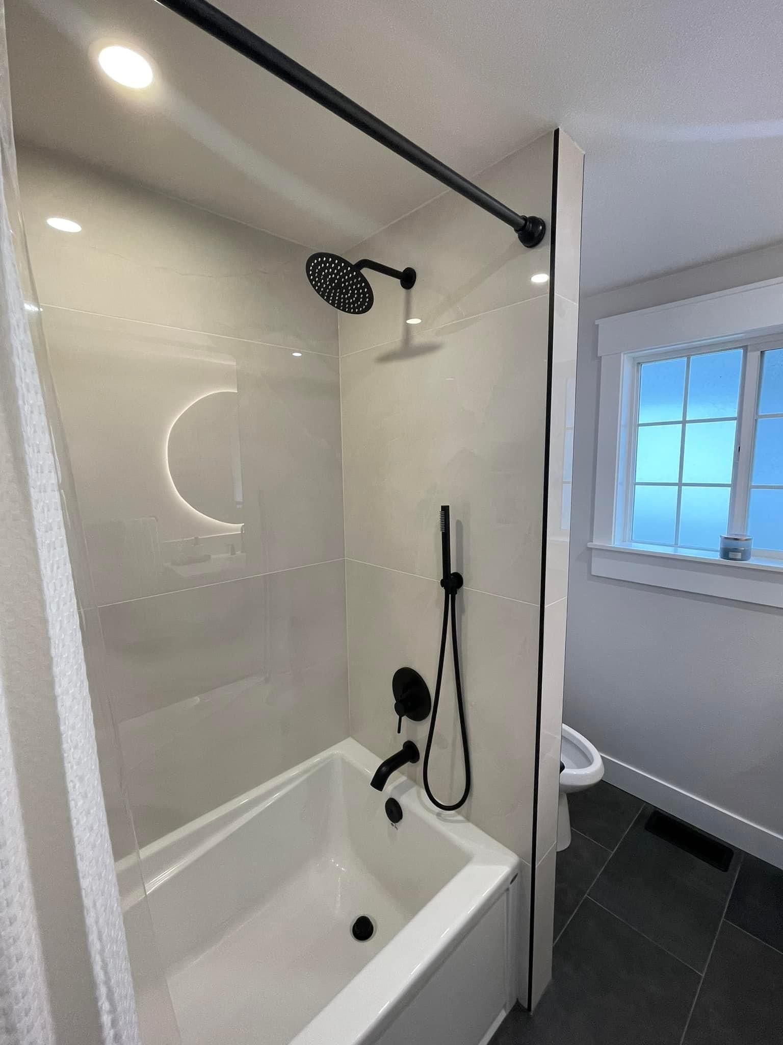 A modern bathroom featuring a white bathtub, black shower fixtures, a black shower curtain rod, and a window.
