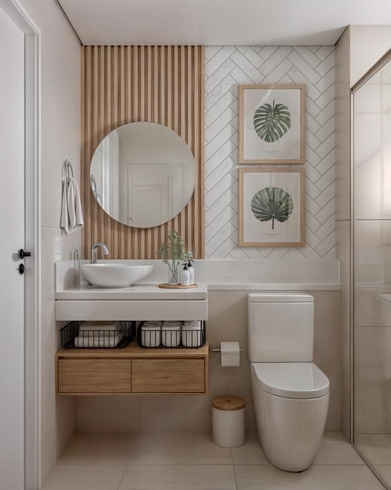 A modern bathroom with a white sink on a wood vanity, a round mirror, slatted wood wall, and white herringbone tiles.