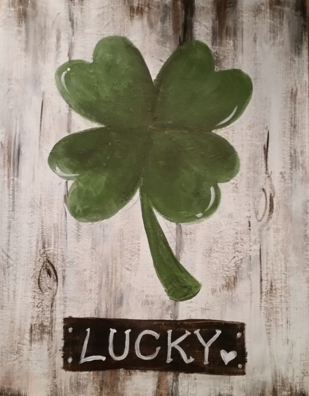 A painting of a four leaf clover with a sign that says lucky
