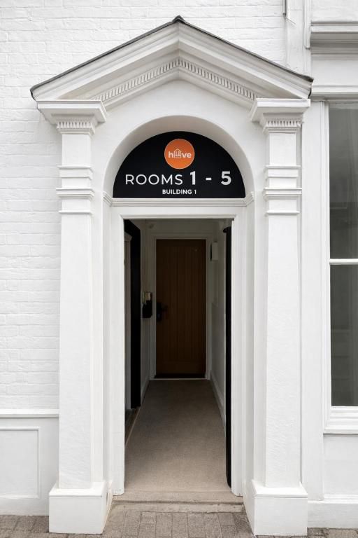 White doorway with orange circle sign above reading
