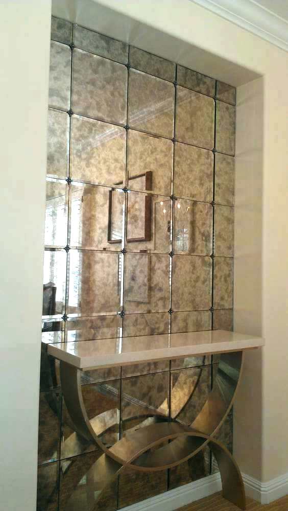 Mirrored wall niche with decorative console table in a hallway, framed by beige walls
