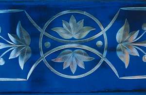 Blue decorative panel with white floral and circular geometric patterns