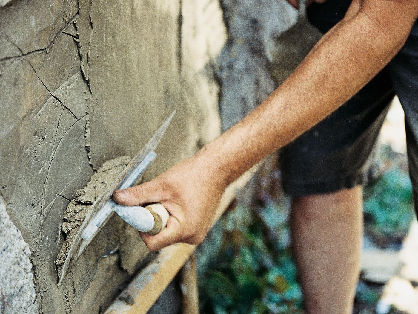 a person applying stucco to a wall during repair