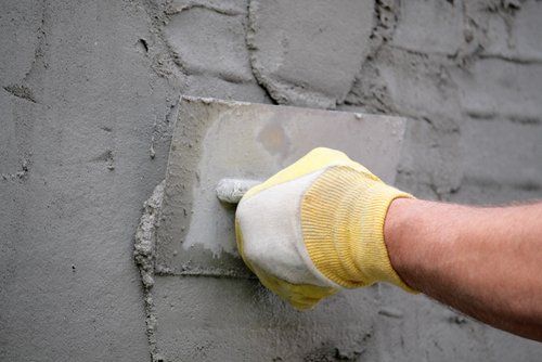 a person applying stucco to a wall during repair