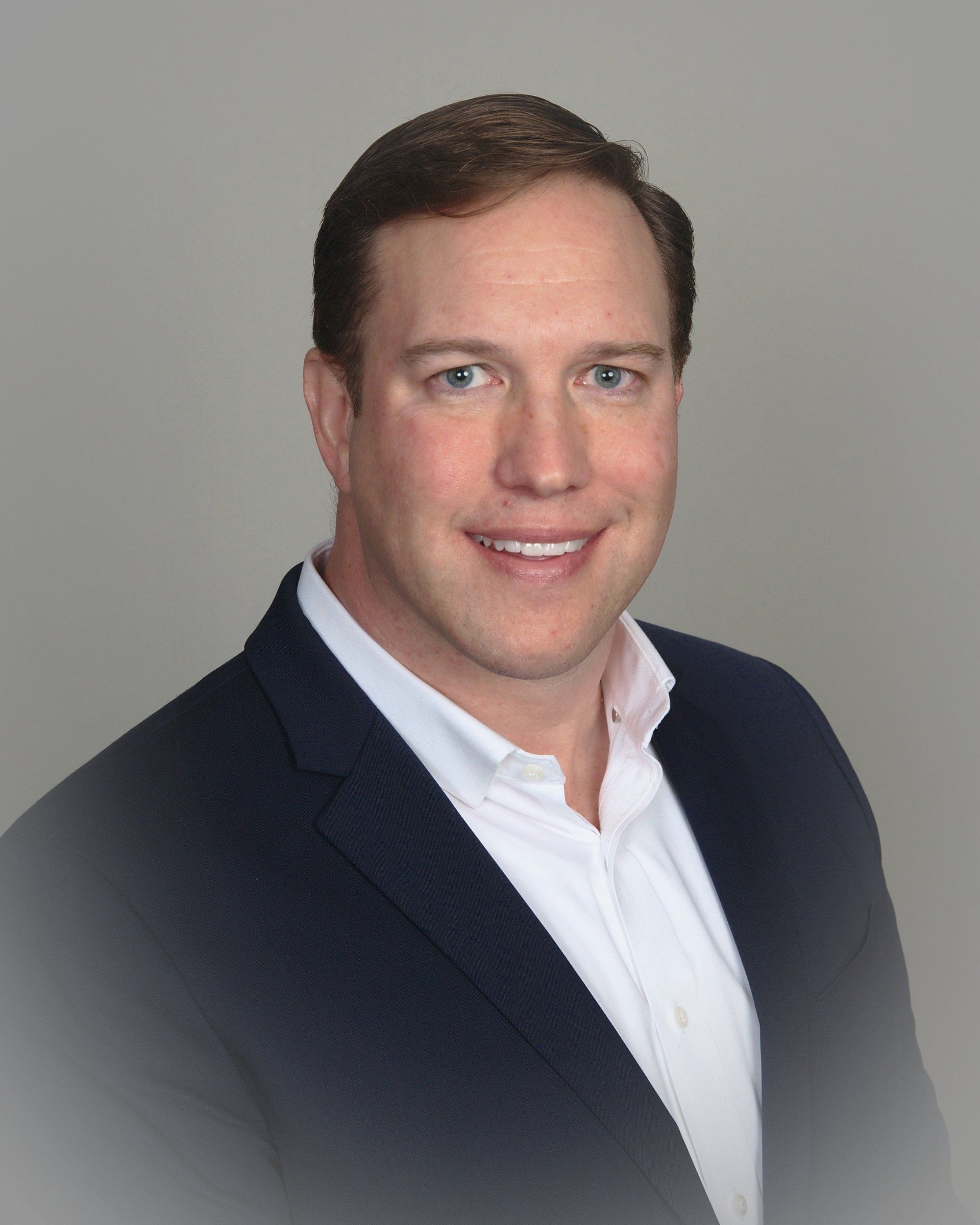 A man in a suit and white shirt is smiling for the camera. His name is Jeffrey Broderick.