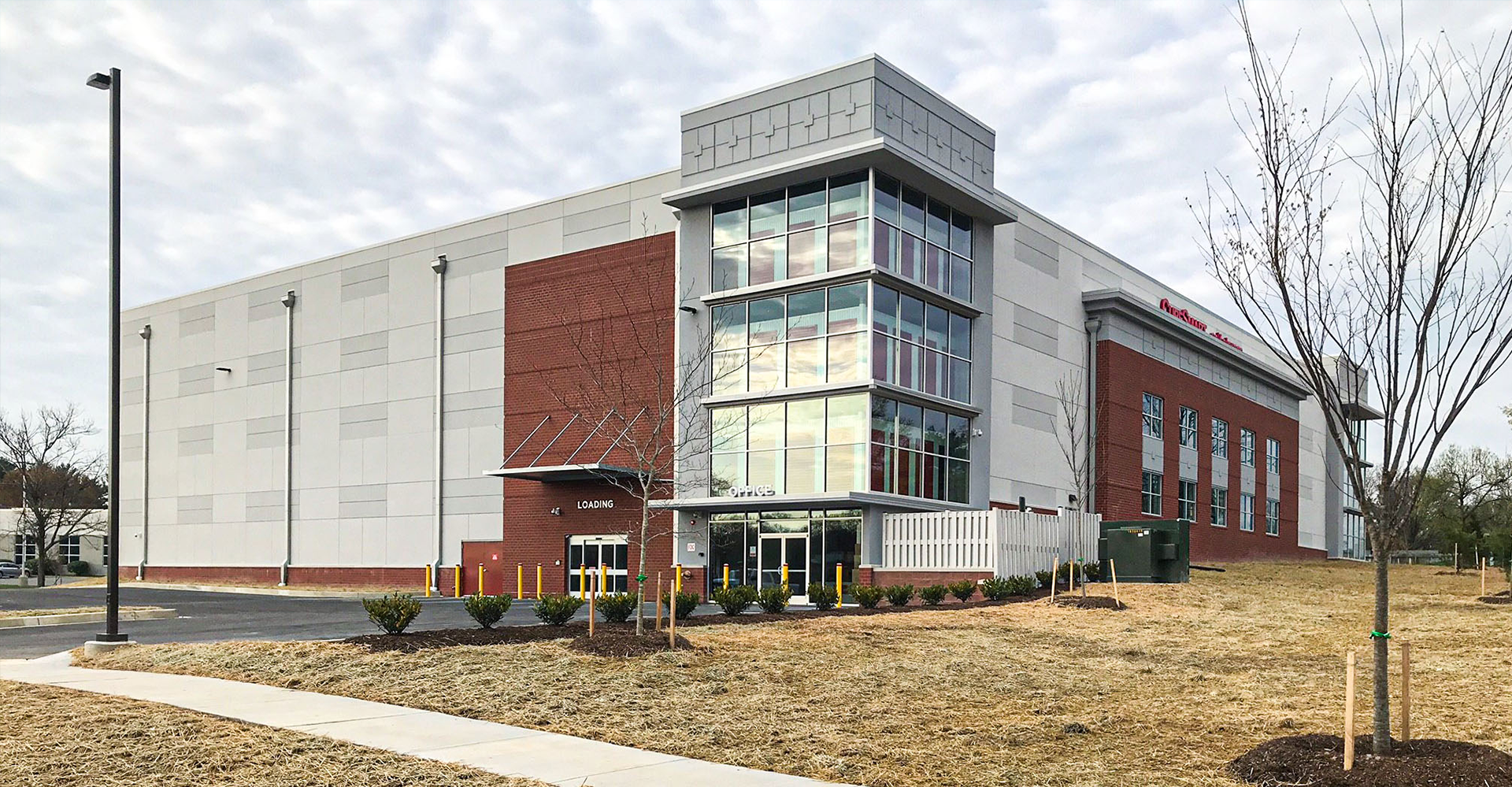 Large modern building with brick and glass facade, blue sky.