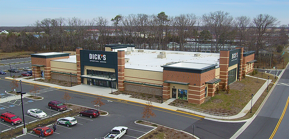 Aerial view of a large retail store with a parking lot and a road.