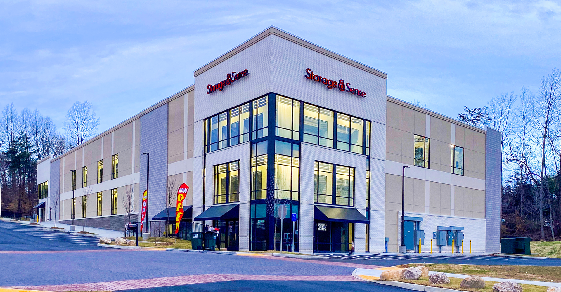 Storage Sense building with modern design, glass entrance, and red sign. Exterior shot on a clear day.