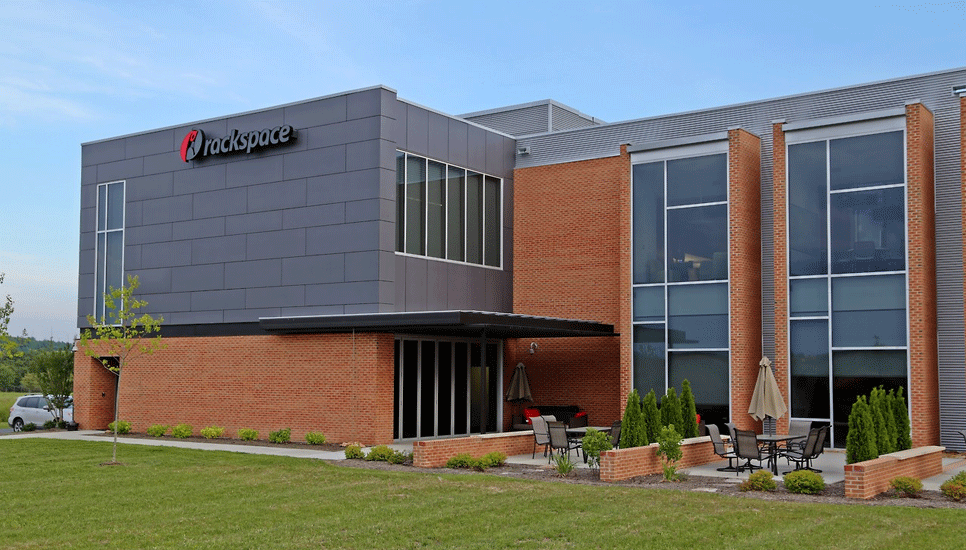 Modern building with red brick, gray siding, and large windows. 