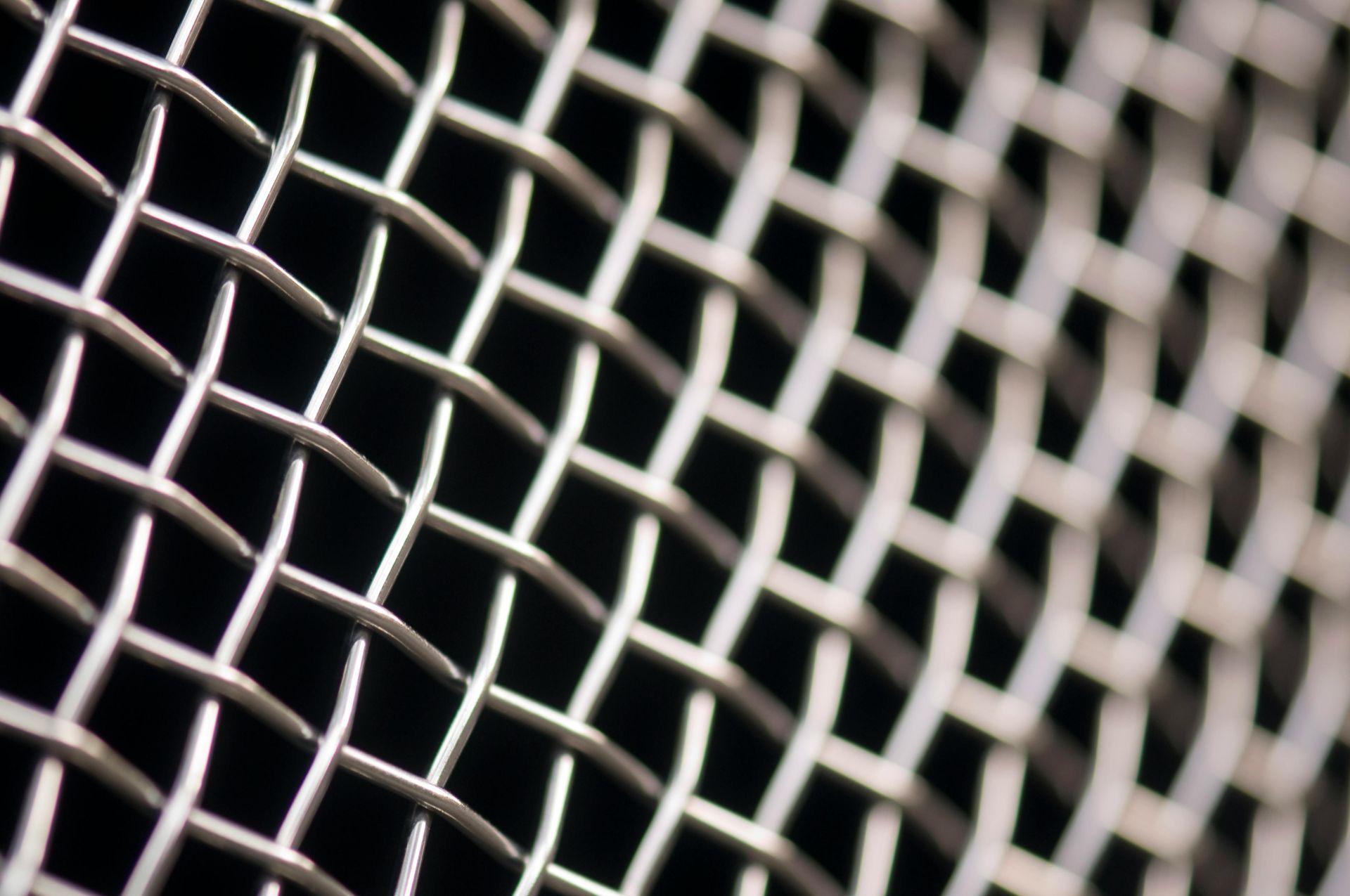 A close up of a metal mesh on a black background