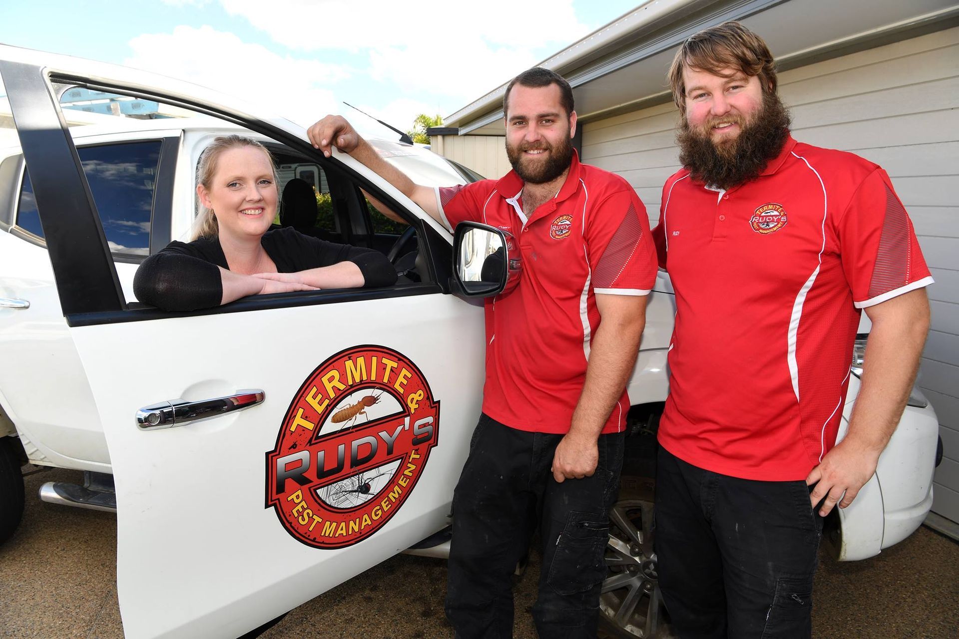 Three People Posing Beside a White Vehicle With a Red Logo — Rudy's Carpet Cleaning & Pest Management In Sharon, QLD
