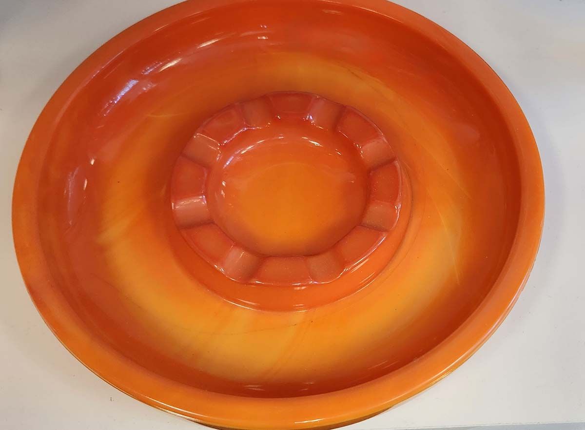 An orange bowl with a circle in the middle of it