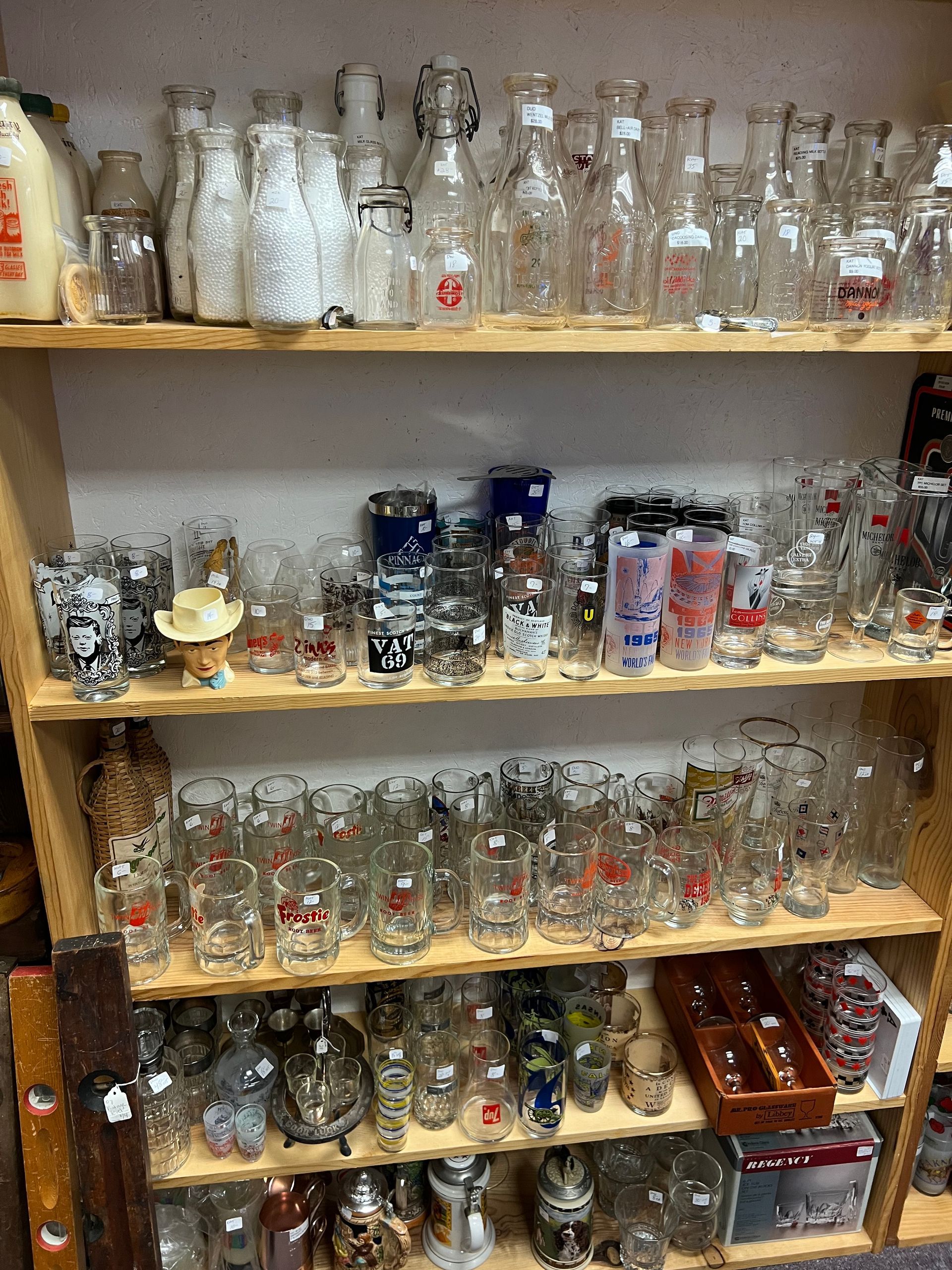 A shelf filled with lots of collective glass and bottles