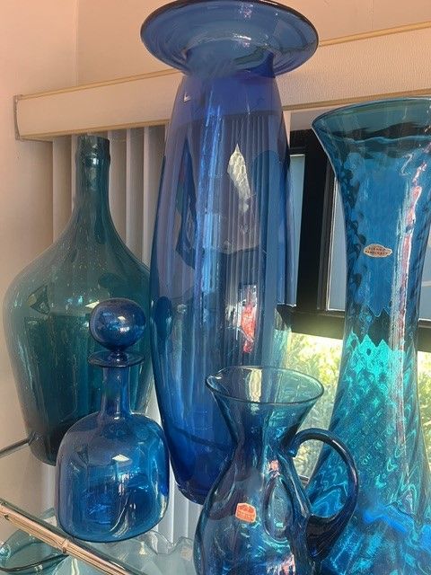 A bunch of blue vases and bottles on a shelf