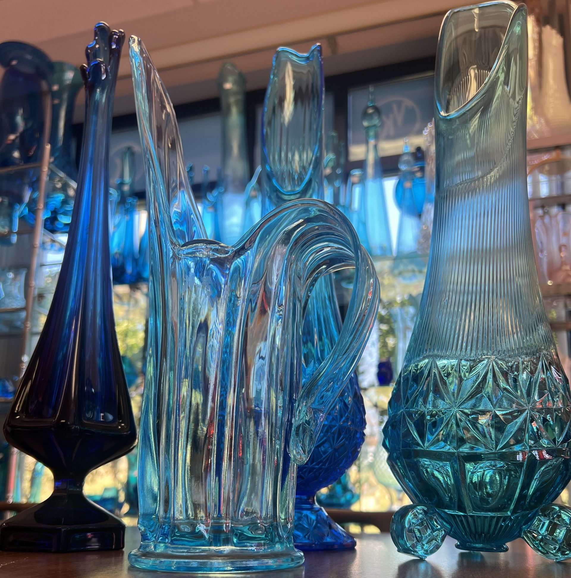 A collection of blue swung glass vases