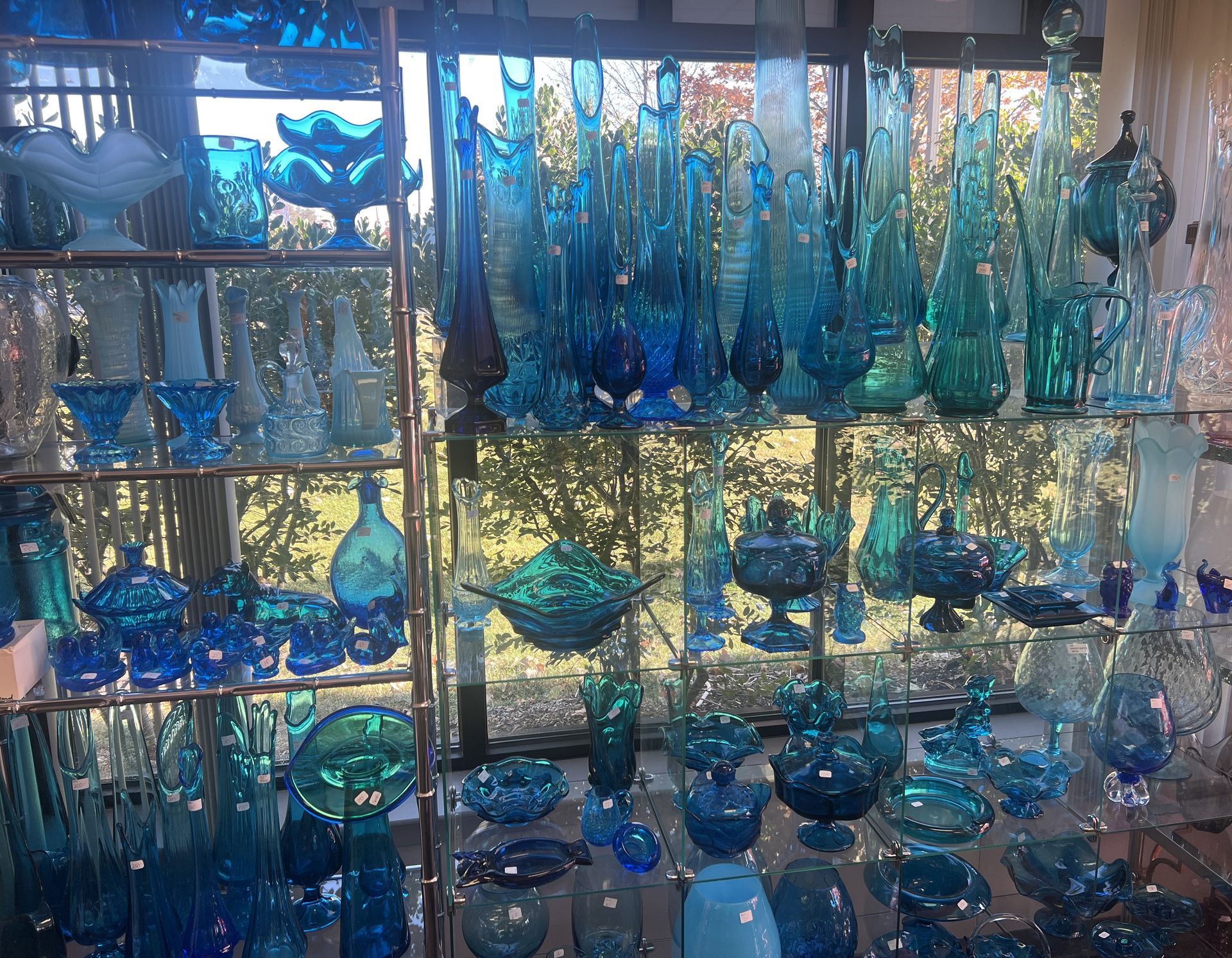 A display of blue glassware including vases and bowls
