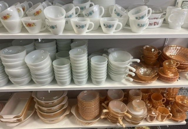 A shelf filled with a variety of bowls and cups.