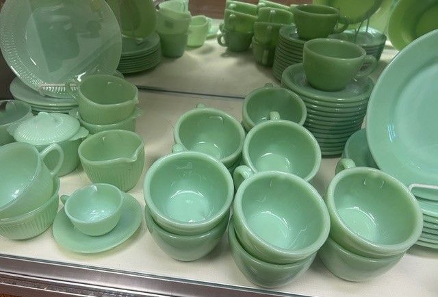 A bunch of green cups and saucers on a table