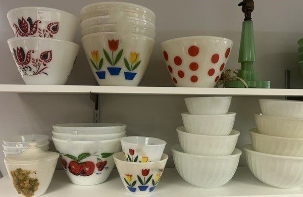 A shelf full of bowls with different designs on them