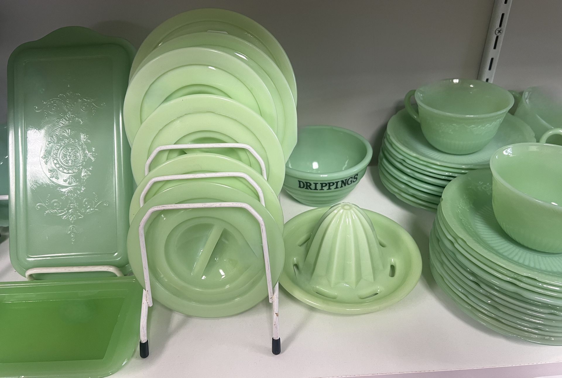 A display of green glass dishes and bowls on a shelf