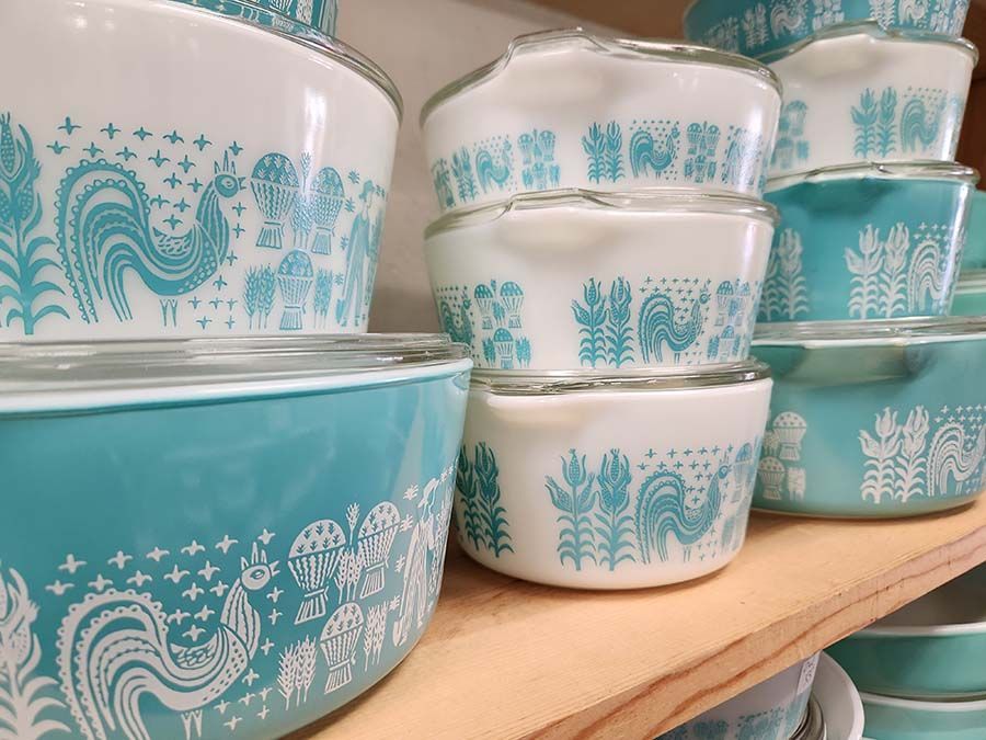 A row of blue and white pyrex dishes on a wooden shelf
