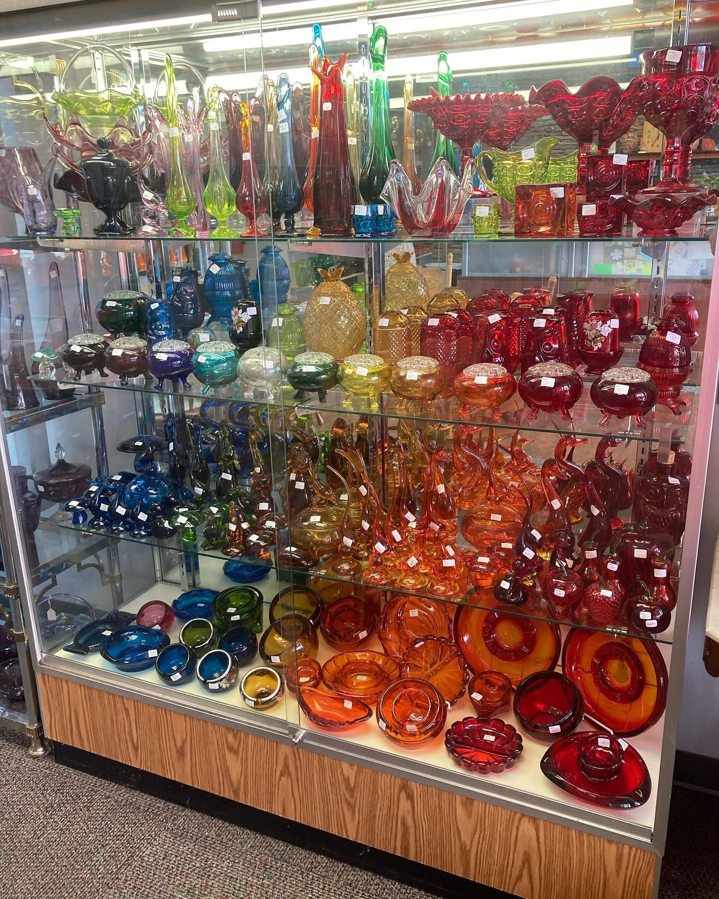 A glass display case filled with many different colored glass items