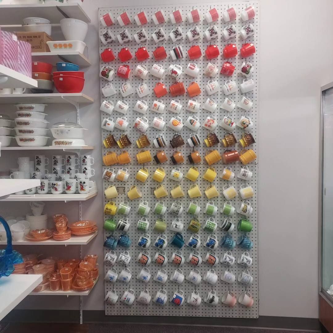 A wall filled with lots of different colored coffee mugs