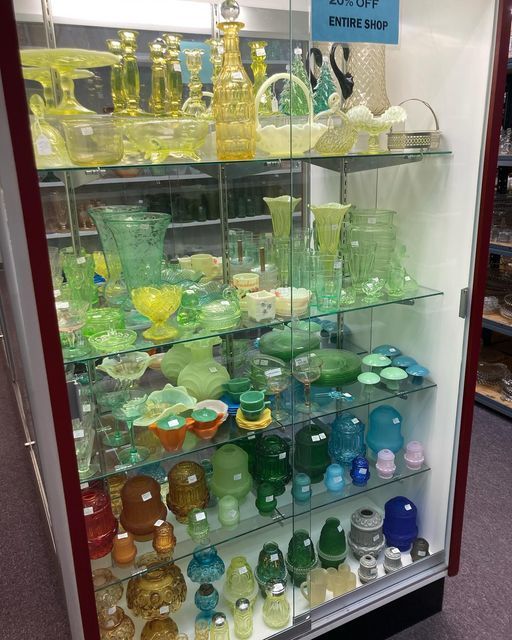 A glass display case filled with a variety of glassware
