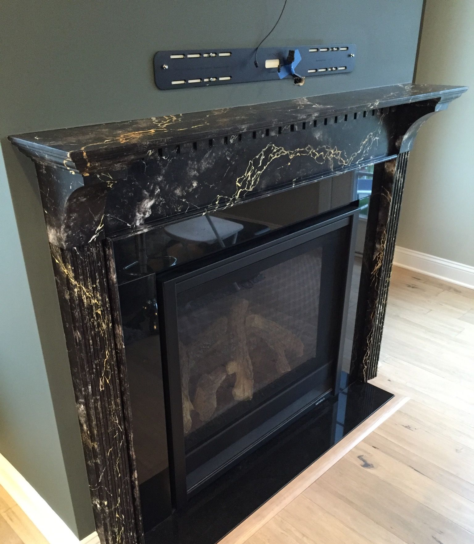 Fireplace with fluted marble columns and wall-mounted bracket.