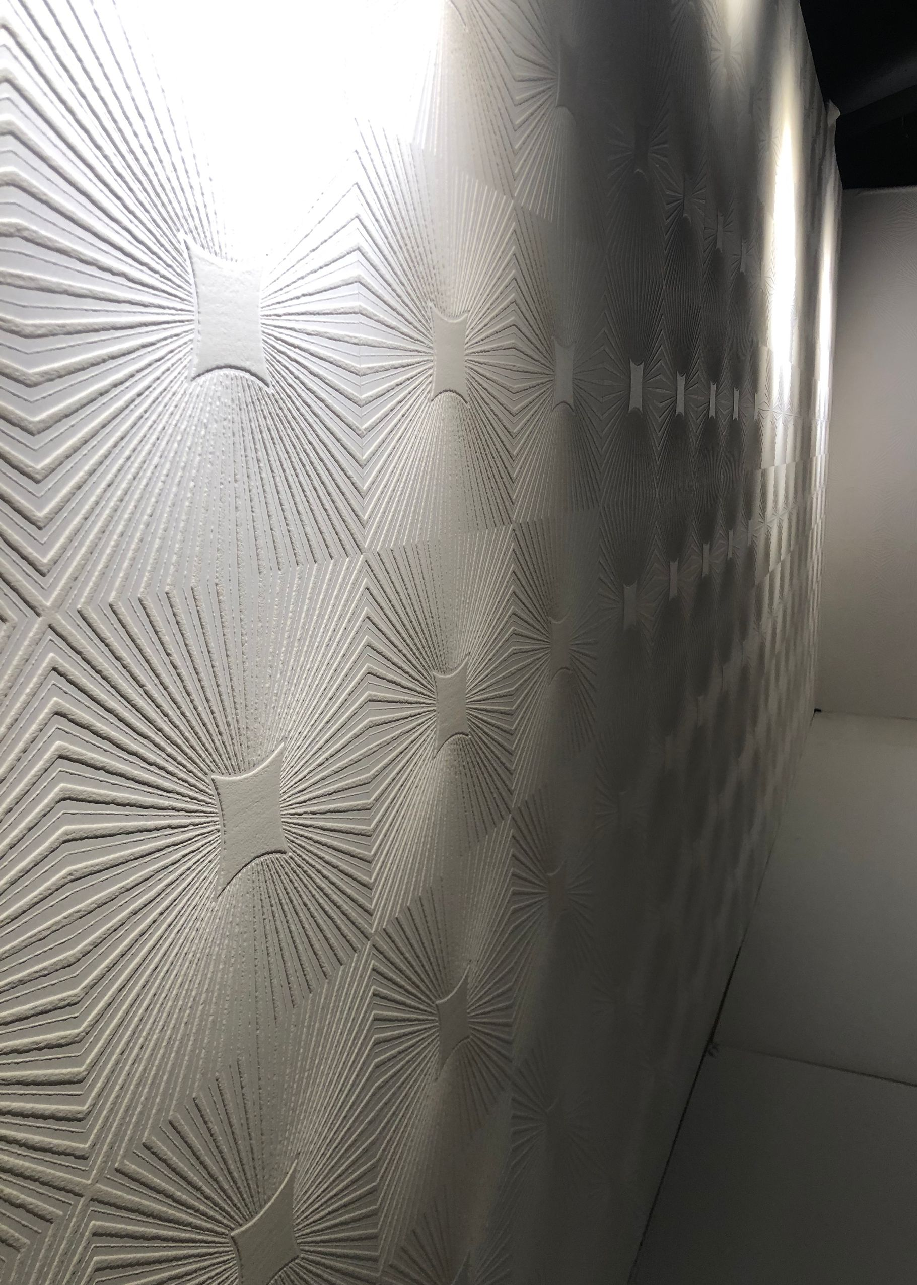 Geometric mural with starburst texture and dramatic lighting.
