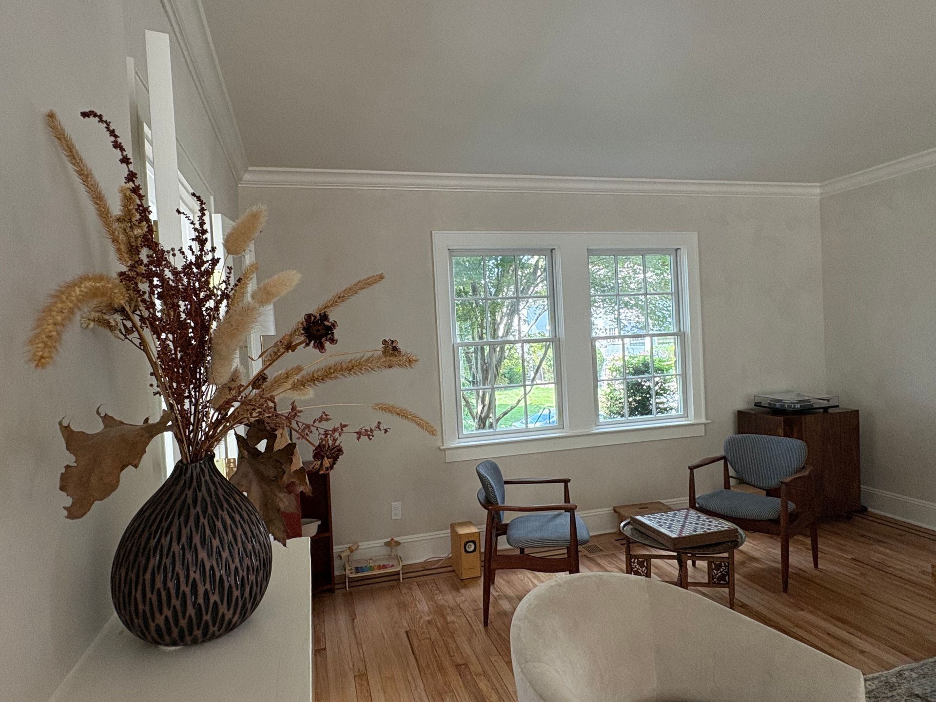 Living room mural with blue chairs, turntable, and window view.