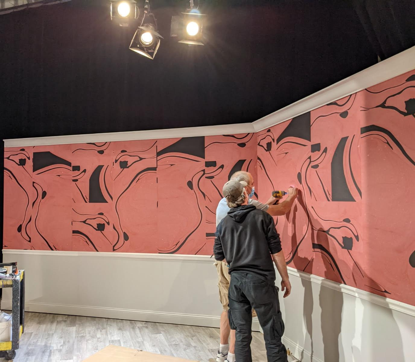 Mural installation: pink abstract wall with black organic shapes.