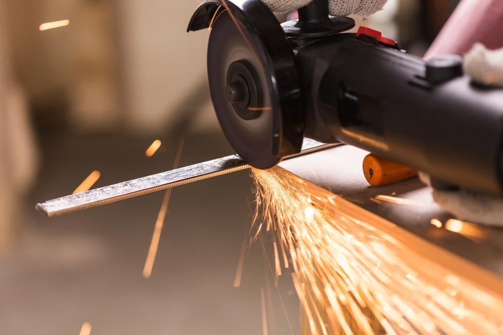 Angle Grinder Cutting a Metal Strip — Sheetmetal Improvements & Design in Yatala, QLD
