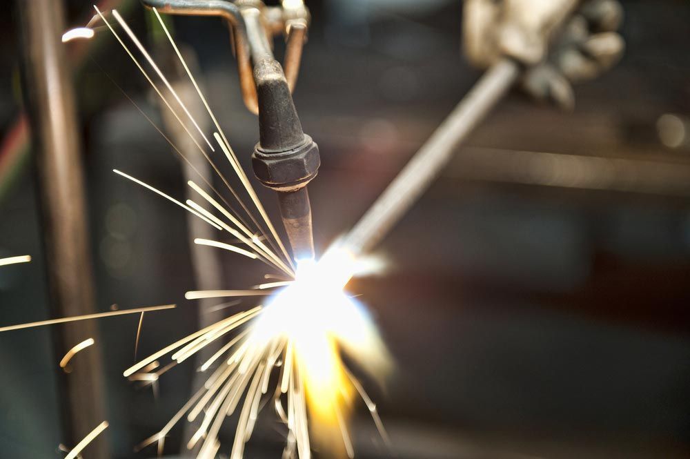 Welder Using a Torch, Creating Sparks in a Workshop Setting — Sheetmetal Improvements & Design in Burleigh Heads, QLD