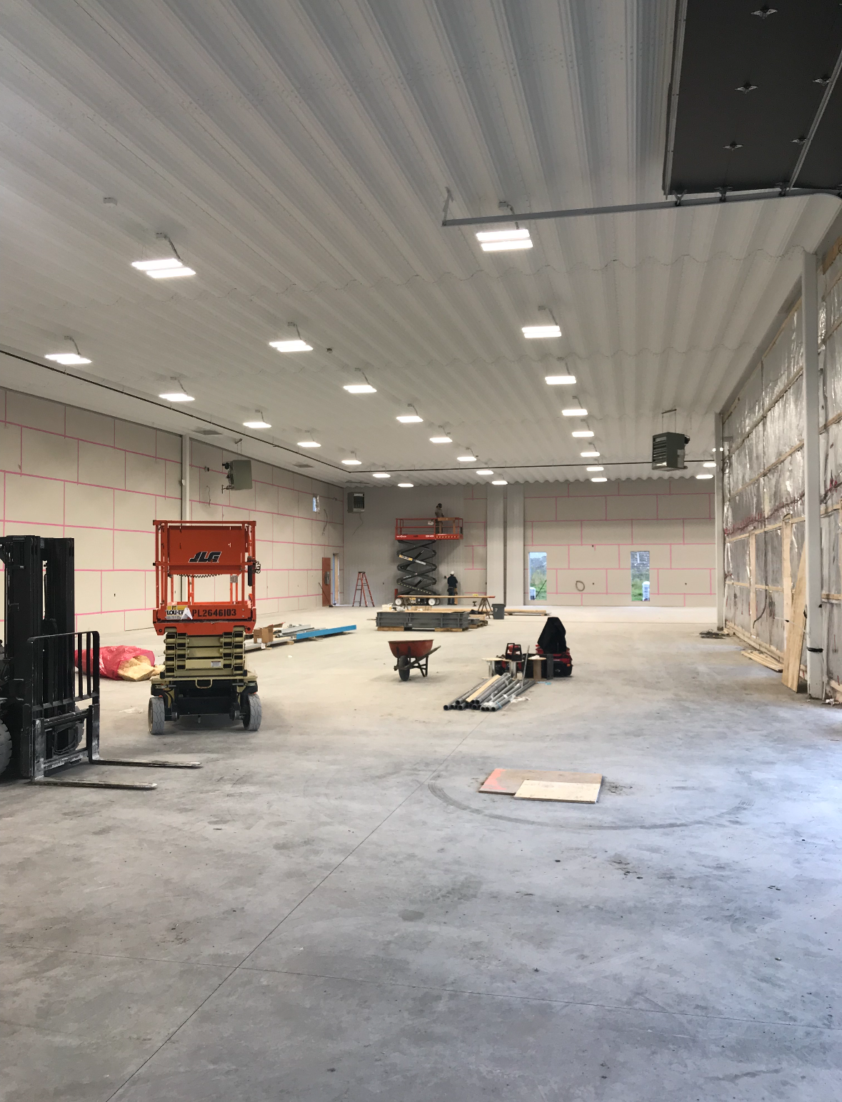 Des rangées de lumières fluorescentes illuminent l'intérieur d'un magasin ; des présentoirs de marchandises se trouvent en dessous.