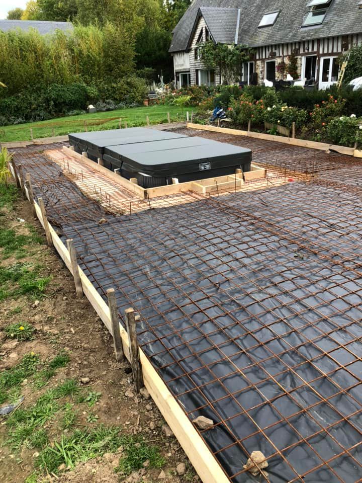 Chantier de construction avec treillis d'armature et coffrage en bois pour une fondation en béton dans un jardin