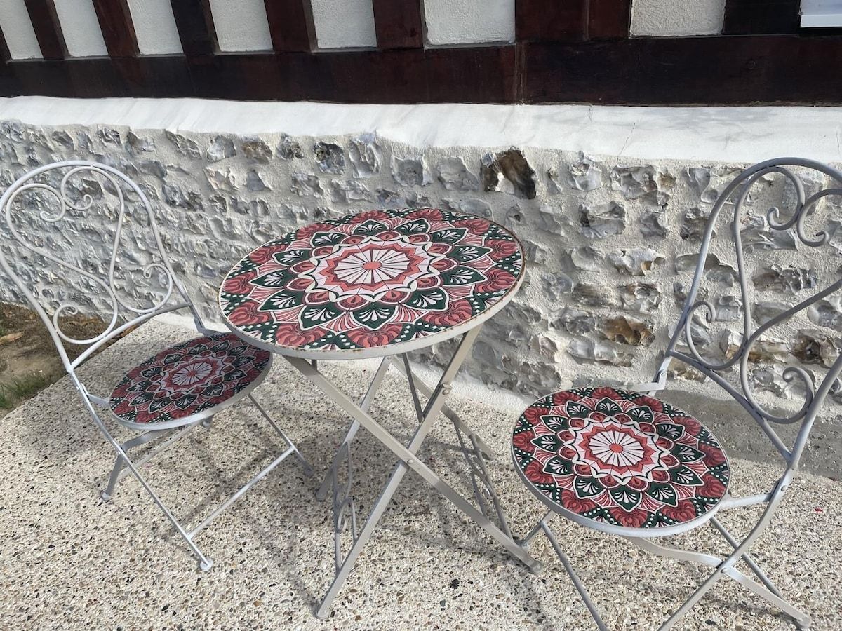 Petite table ronde en mosaïque et deux chaises pliantes assorties sur une terrasse en pierre.