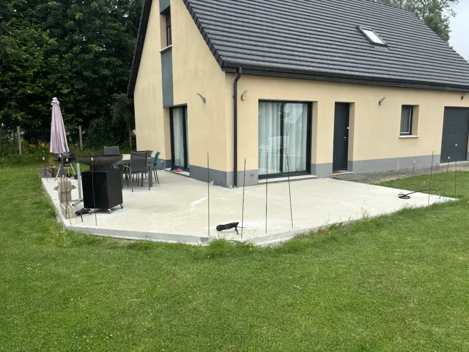 Vue du coucher de soleil sur une terrasse de jardin avec un jacuzzi, des marches et un petit chien sur la pelouse.