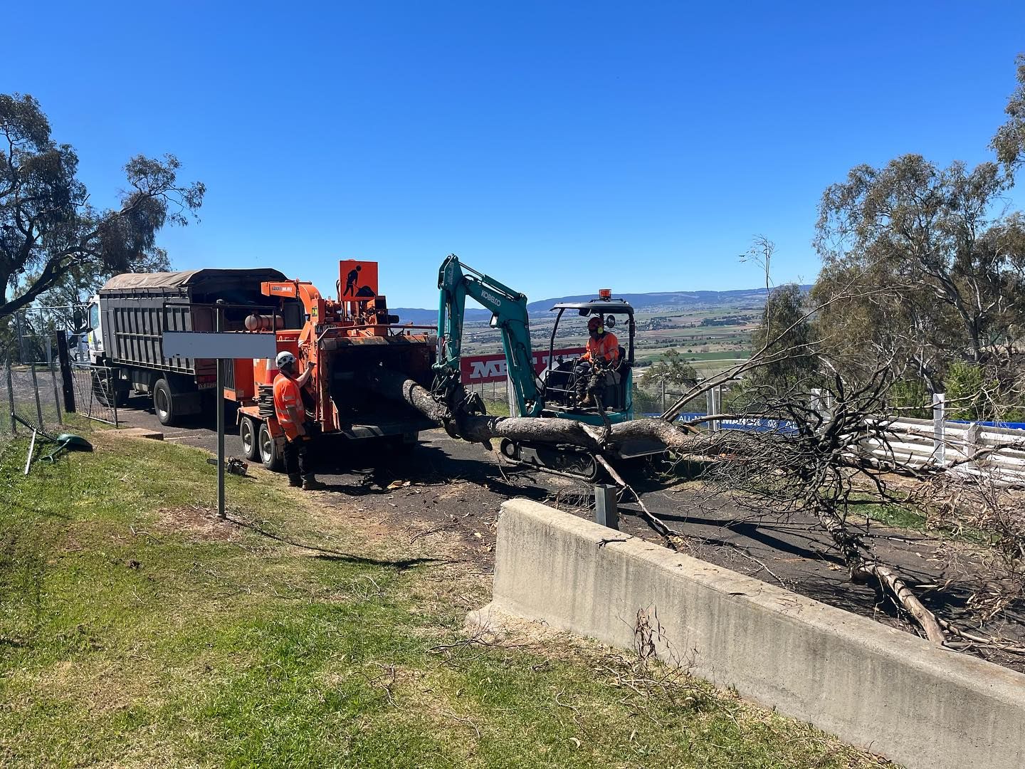 Crews Using a Chipper, Truck, and Excavator to Remove Logs From Roadside — Agile Arbor Pty Limited in Oberon, NSW