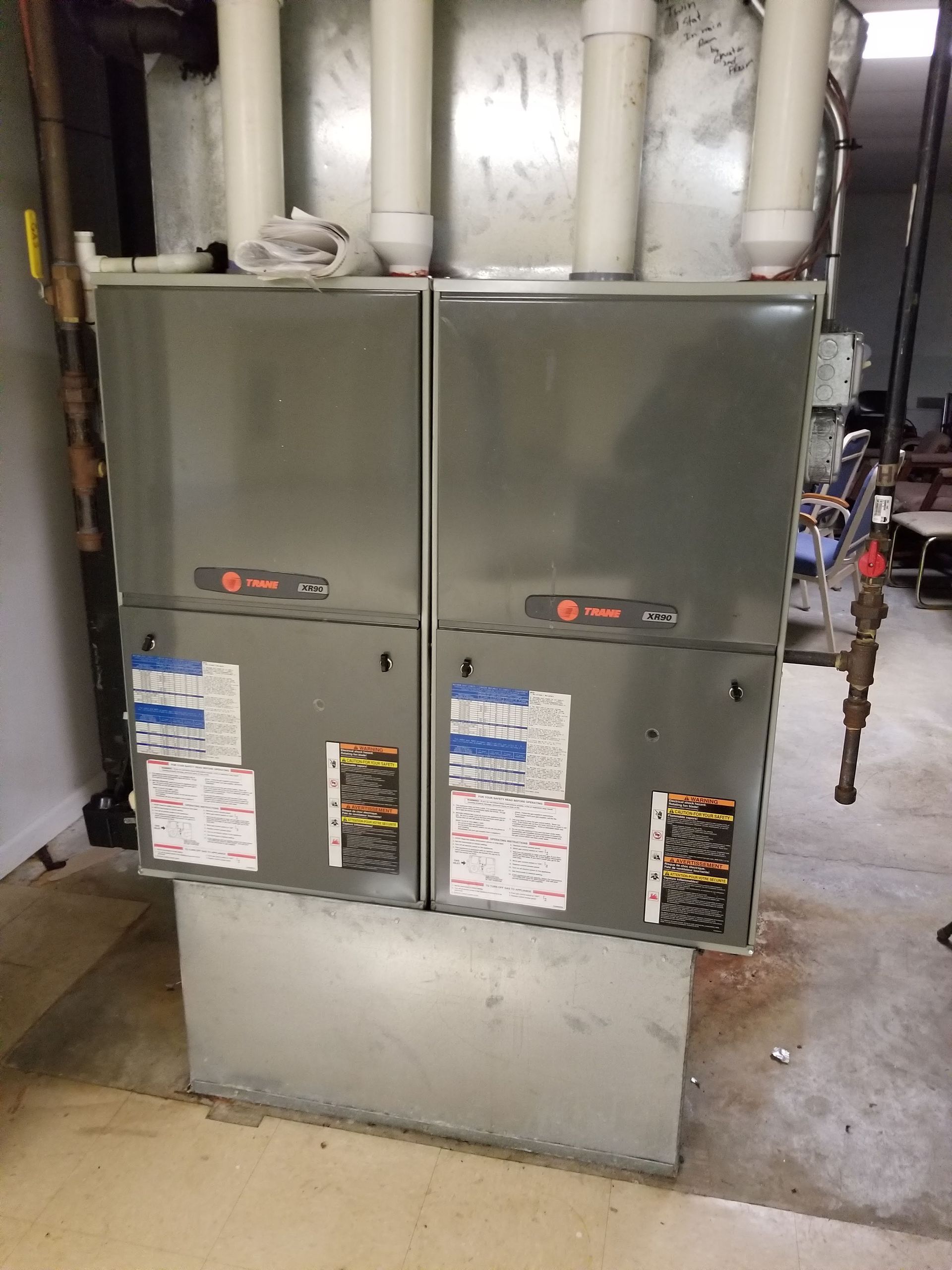 A heating and cooling system is sitting on the floor in a room.