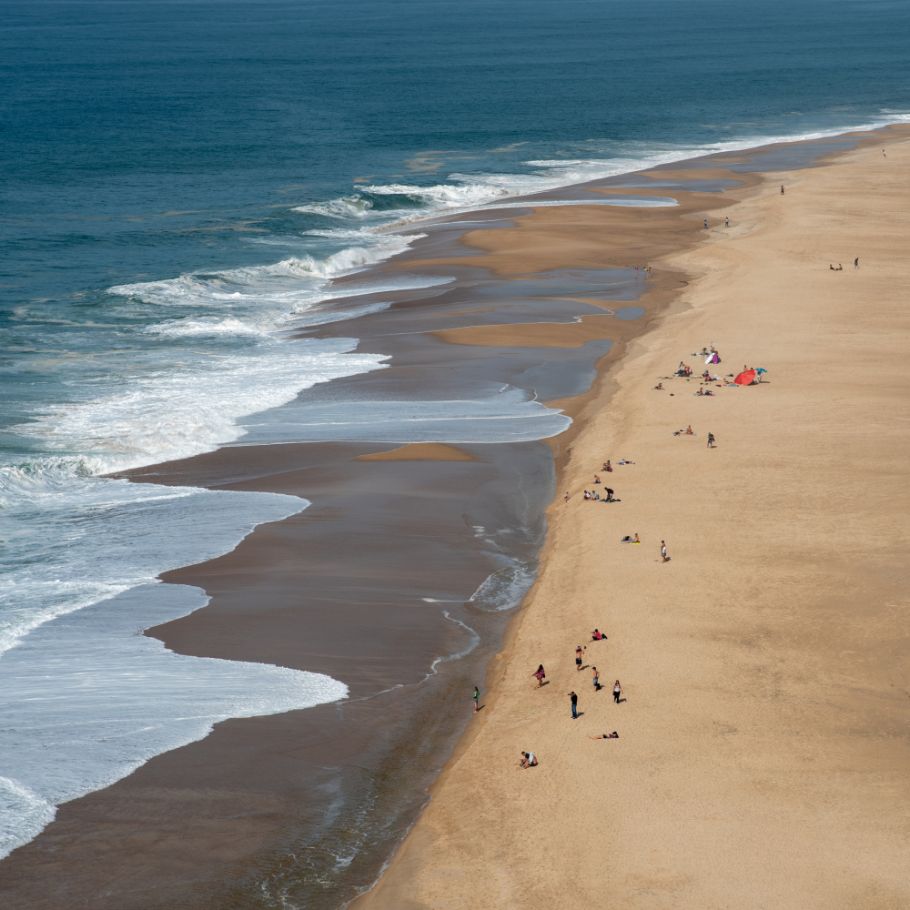 An aerial view of a beach with people walking on it