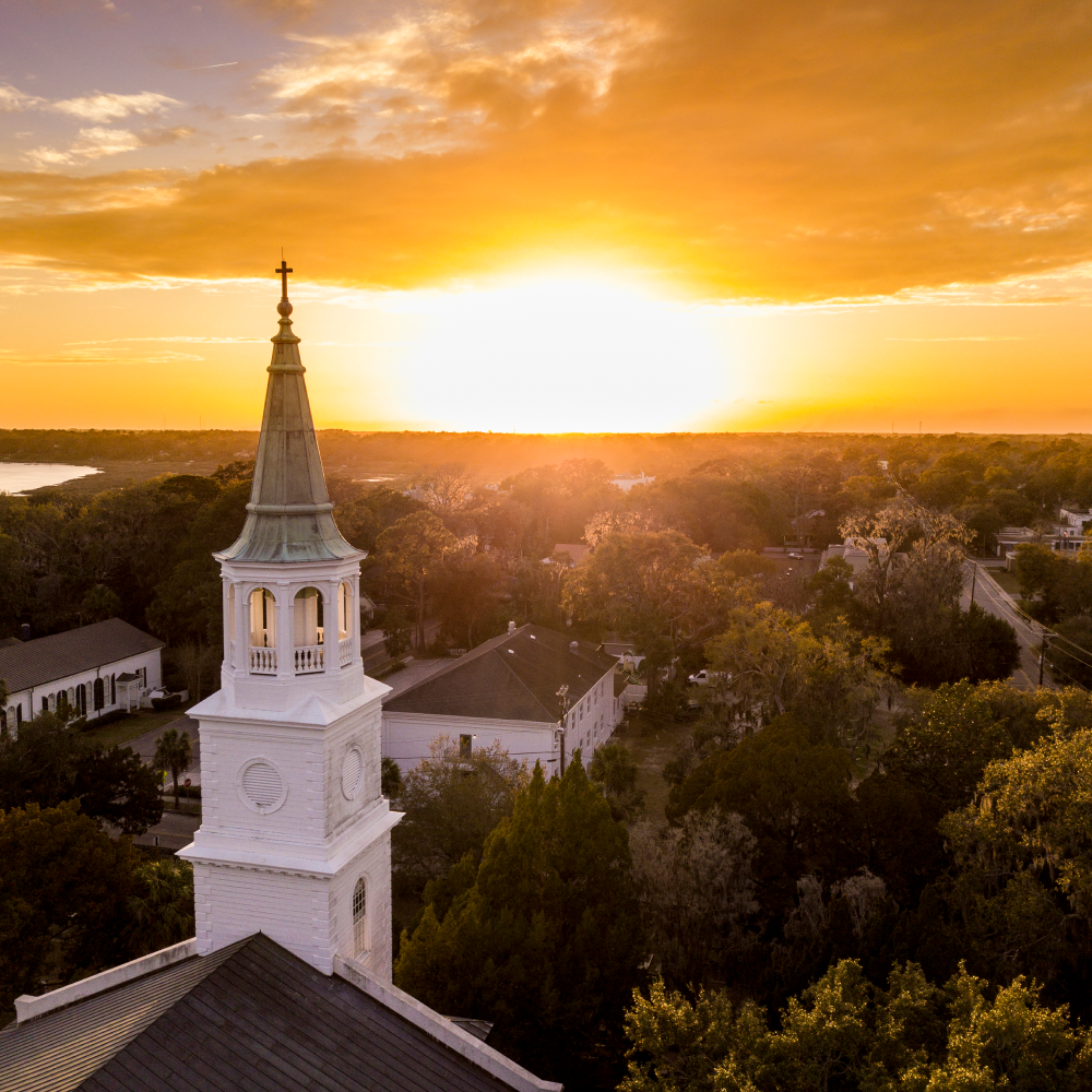 An aerial view of a church tower at sunset