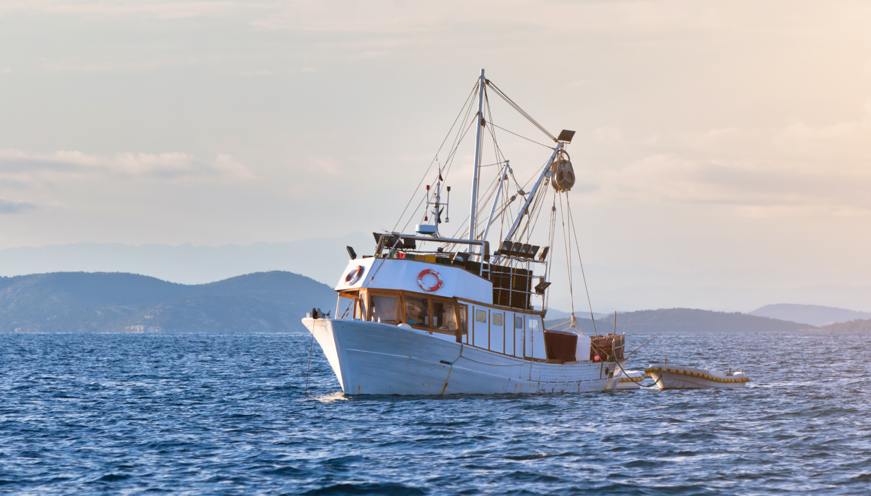 A large white boat is floating on top of a large body of water.