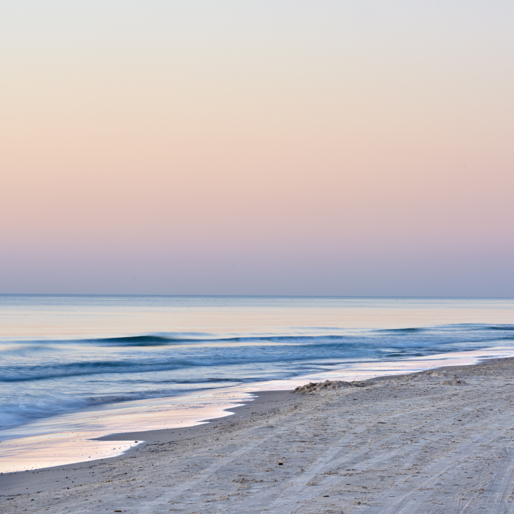 A beach with a sunset in the background