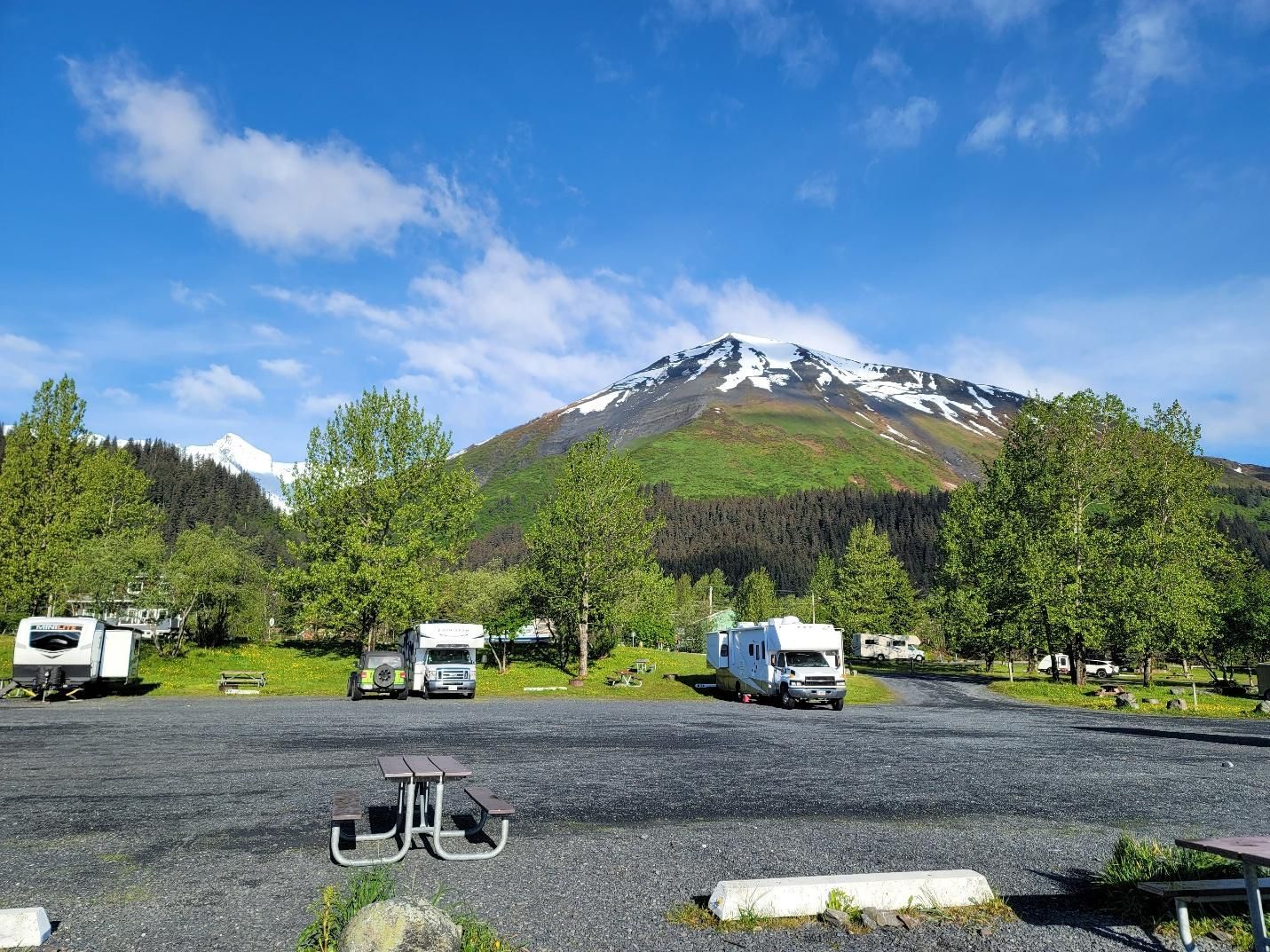 A group of rvs parked at Seward waterfront park with Kenai Fjords National Park in the background